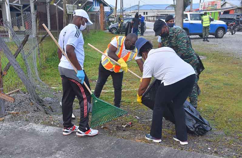 Minister within the Office of the Prime Minister, Kwame McCoy (second from left), assisting with the clean-up
