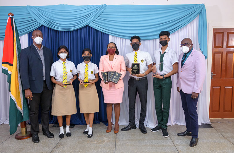 Chief Education Officer Dr Marcel Hutson (right) MoE Permanent Secretary, Alfred King (left) and Principal of QC (centre) with some of the awardees (from left) QC students Roshni Samaroo, Sarena Razak, Samuel Haynes and Naresh Jagnanan of the Essequibo Islands Secondary School (Delano Williams photo)