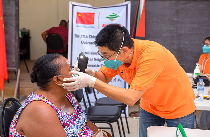 The ophthalmologist examines a resident of Kwakwani (Delano Williams photo)