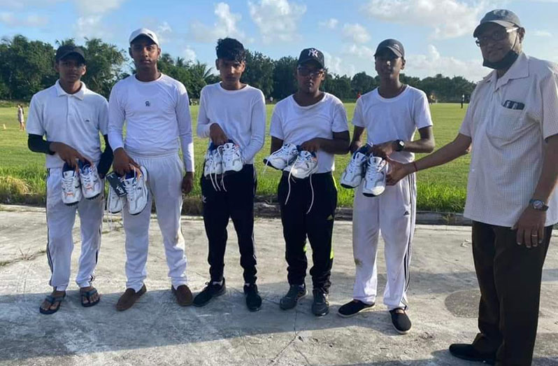 President of Essequibo Cricket Board, Deleep Singh, hands over the cricket shoes to the young cricketers