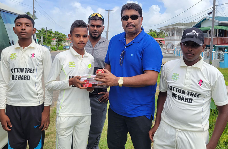 Anil Beharry (right) hands over the balls to Awaza Gaffur of Cotton Tree