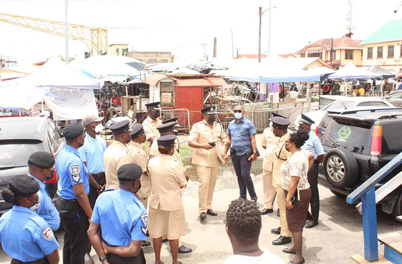 Divisional Commander, Assistant Commissioner Simon McBean, (centre) speaking with other law enforcement ranks at the Stabroek Market, on Wednesday