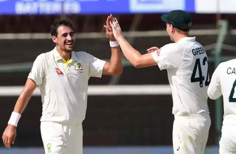 Mitchell Starc (left) celebrates after taking one of his three victims.
