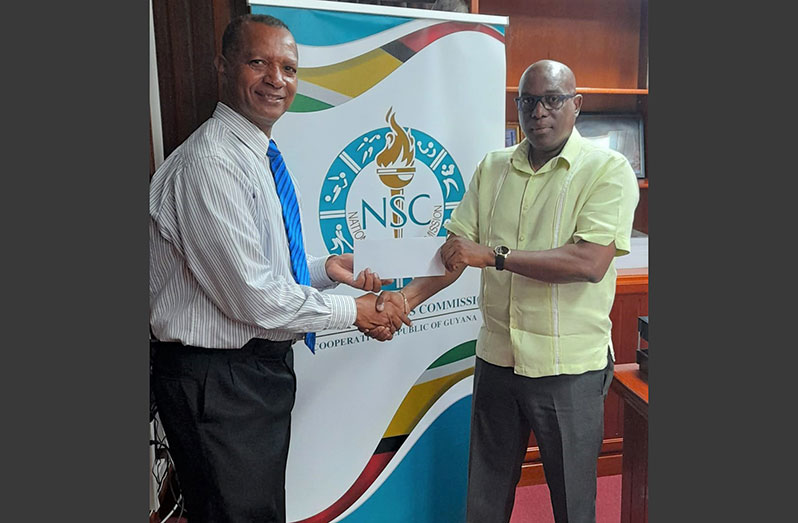 AAG president Aubrey Hutson (L) receives the NSC’s $2M cheque from Director of Sport, Steve Ninvalle