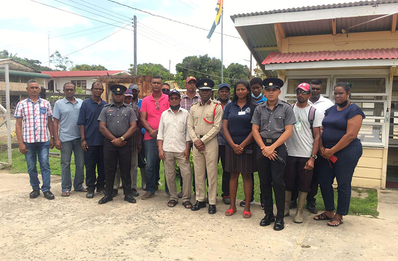 Chief Fire Officer (ag) Gregory Wickham (centre) flanked by auxiliary firefighters, residents and other officials of Leguan