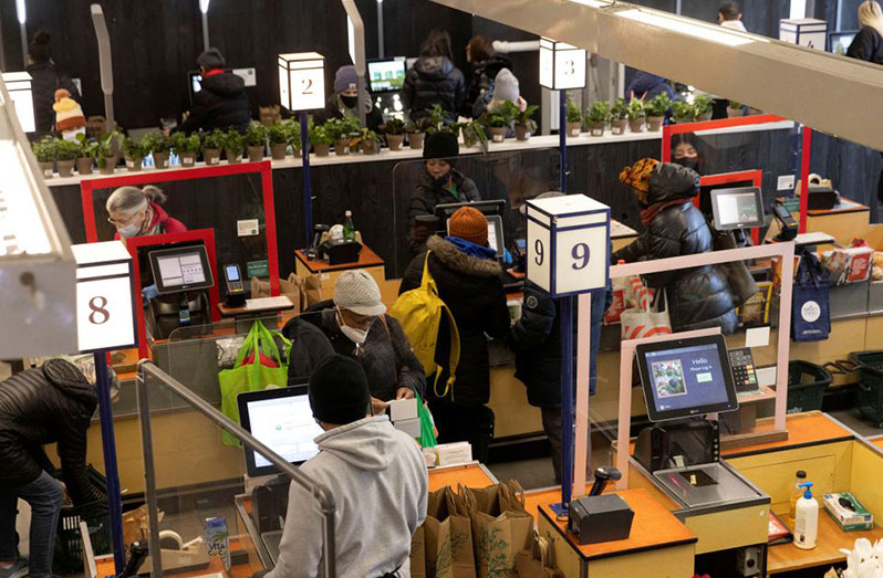 People pay for their purchases at a supermarket in Manhattan, New York City, U.S.