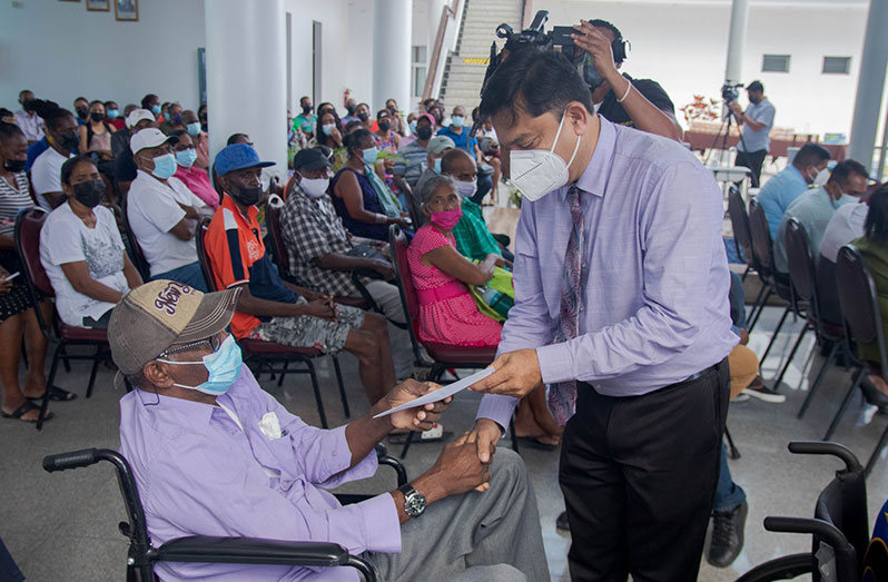 One of the beneficiaries of the government dialysis programme receives his cheque from Chief Medical Officer, Dr Narine Singh (Ministry of Health photo)