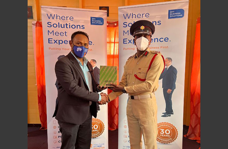 Business Solutions Sales Lead Vishwanath Ishwardin (left) handing over one of the phones to Fire Chief (ag) Gregory Wickham