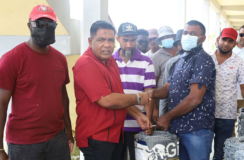 Minister Mustapha handing over a bundle of the fencing materials to a member of the Yakusari Cattle Association Corporation