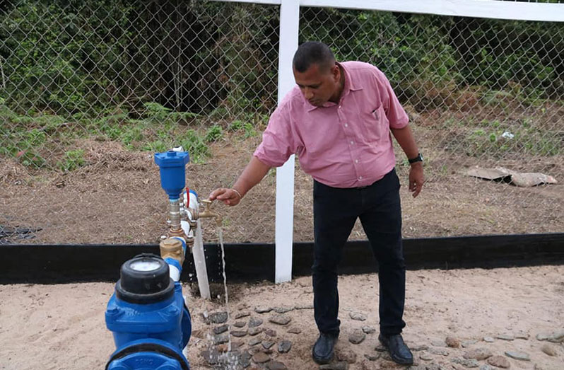 Minister of Housing and Water, Collin Croal, tests the Kaibarupai Water Supply System