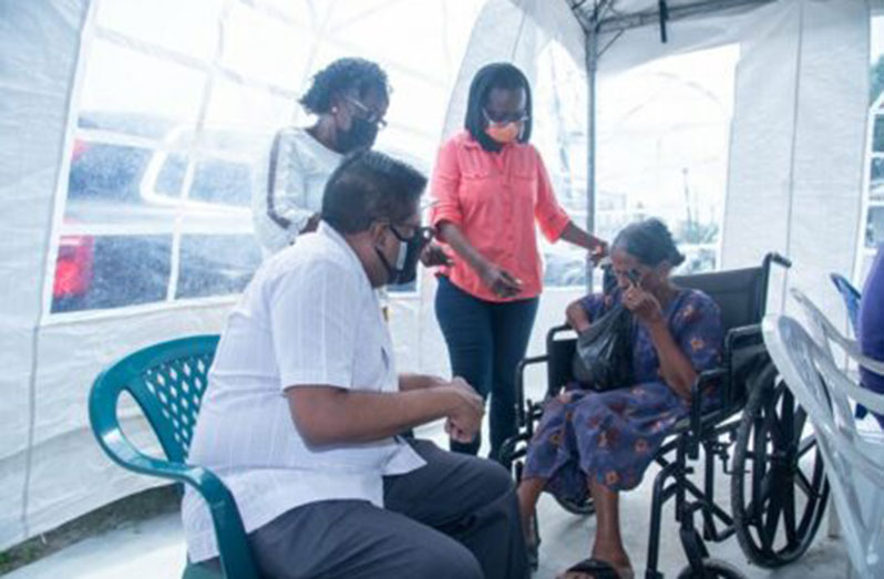 Senior Minister within the Office of the President with responsibility for Finance, Dr Ashni Singh listens to the concerns of a senior citizen at the NIS Outreach at Enterprise, East Coast Demerara (DPI photo)