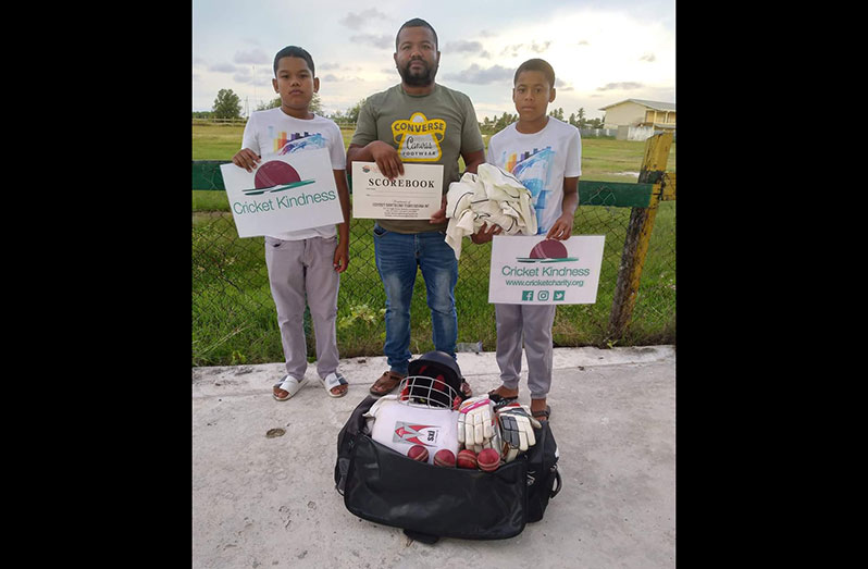 Danny Hodge (centre) of Hururu Ladernville, Upper Berbice, was grateful as he showed off some of the cricket gear donated by BCB president Hilbert Foster