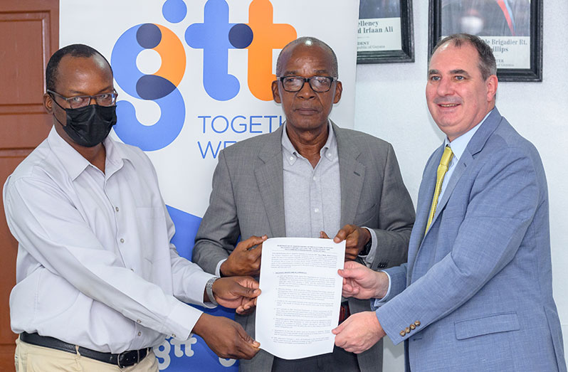GPTWU’s President Harold Shepherd; Labour Minister, Joseph Hamilton and GTT’s CEO, Damian Blackburn, pose for a photo with the signed agreement (Delano Williams photo)