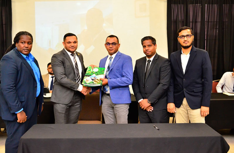 Minister of Natural Resources, Vickram Bharrat, handing over the contract to the auditors in the presence of Permanent Secretary of the Ministry of Natural Resources, Joslyn McKenzie (DPI photo)