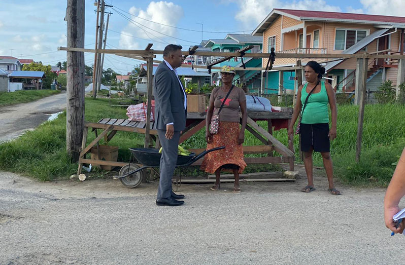 Minister within the Ministry of Public Works, Deodat Indar,  engaging residents, during an inspection of roads in the Hope, Lowland, East Coast Demerara community