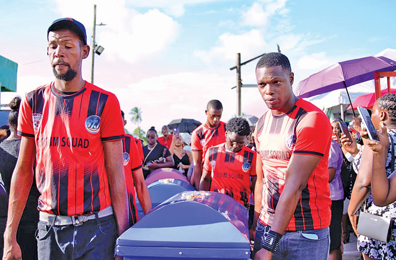 Members of Mocha’s football team, Riddim Squad, carry the caskets containing the remains of the siblings