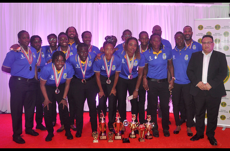 THe Barbados Women’s team pose with GCB president Bissondyal Singh and all their spoils, following Saturday evening’s award ceremony