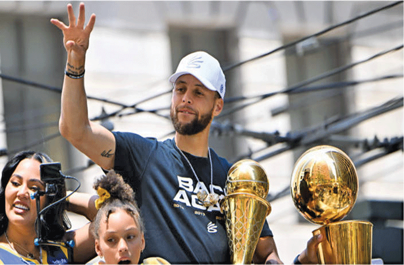 Stephen Curry celebrates   with his trophies  during the Golden State Warriors Victory Parade on  Monday in San Francisco.