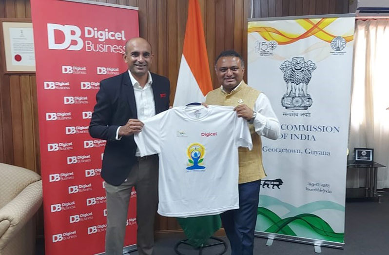 Balaji Vinjimoor, Head of Business Solutions – Digicel Guyana, hands over a quantity of t-shirts to Dr. J. Srinivasa, High Commissioner of India to Guyana, for International Day of Yoga activities hosted by the Indian Cultural Centre (Digicel photo)