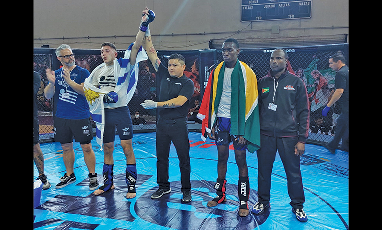 A dejected Trevlon Clarke stands with his coach, Sensei Troy Bobb, while Uruguay’s Cristian Sanchez being announced the winner of their Men’s Welterweight Division, at the IMMAF Pan Am Championships in Monterrey, Mexico. (Rawle Toney photos)