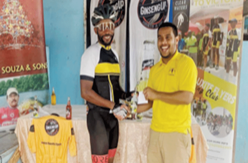 Town Week cycling classic winner, veteran cyclist Nigel London receives his prize from Jeffrey Yearwood of Bauxite Flyers Cycling Club
