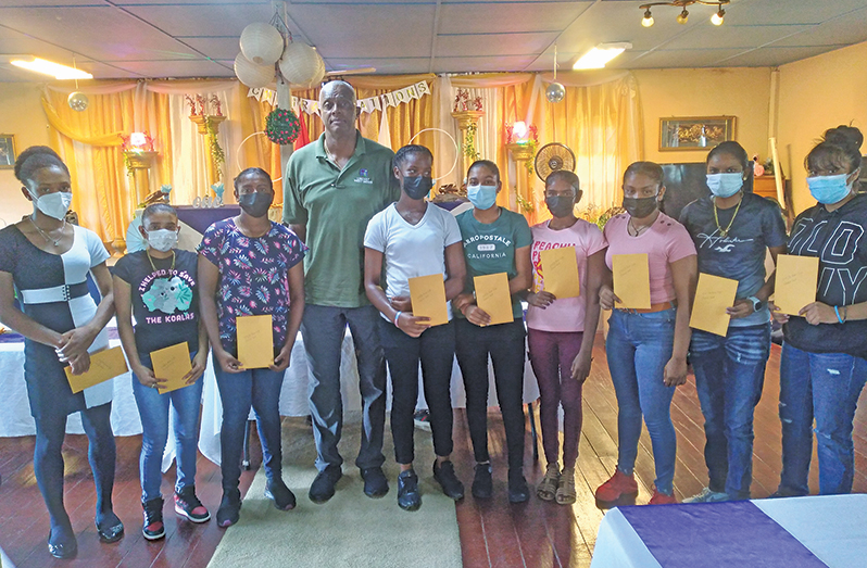 The nine players pose with Courtney Walsh after receiving their stipends
