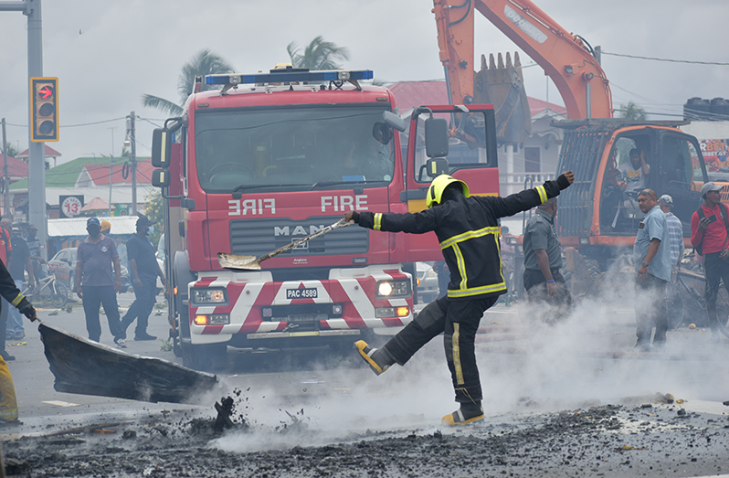 A firefighter clears debris from the roadway (Carl Croker photo)