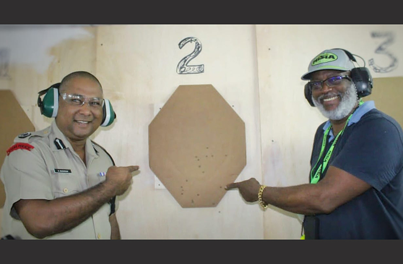 Deputy Commissioner 'Operations' (ag), Ravindradat Budhram and Guyana National Rifle Association, Harold Hopkinson (Range Master) point at the shots that hit the target