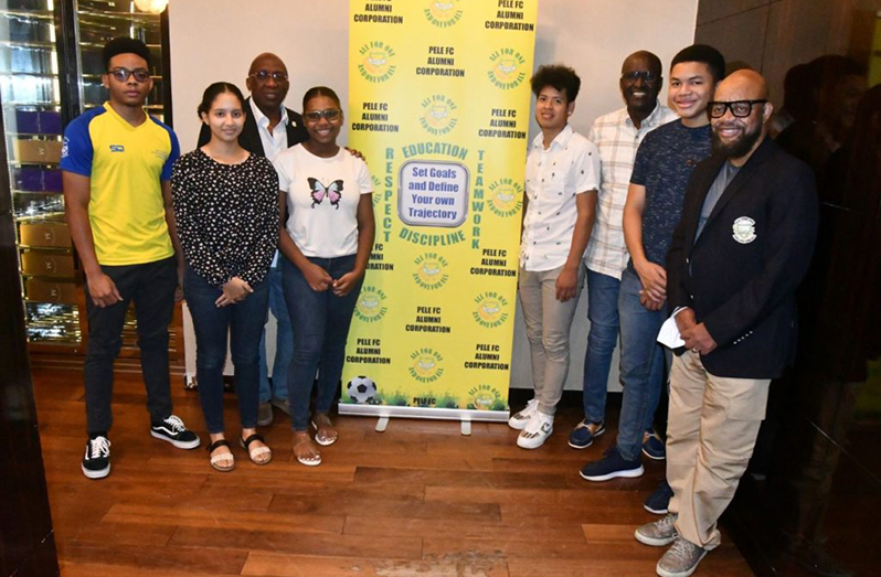 Pele FC Alumni Corporation Executive Committee Members, Patrick ‘Labba’ Barton (right), Eric ‘Riggy’ Smith (third right) and Denis Carrington (third left) pose with the scholarship students at the Marriott Hotel, Kingston, Georgetown