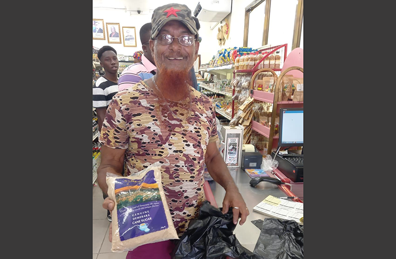 A shopper purchases packaged sugar from the Guyana Marketing Corporation (GMC photo)