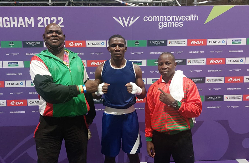 Amsterdam, flanked by coaches Terrence Poole (first from left) and Sebert Blake following his victory at the Commonwealth Games.