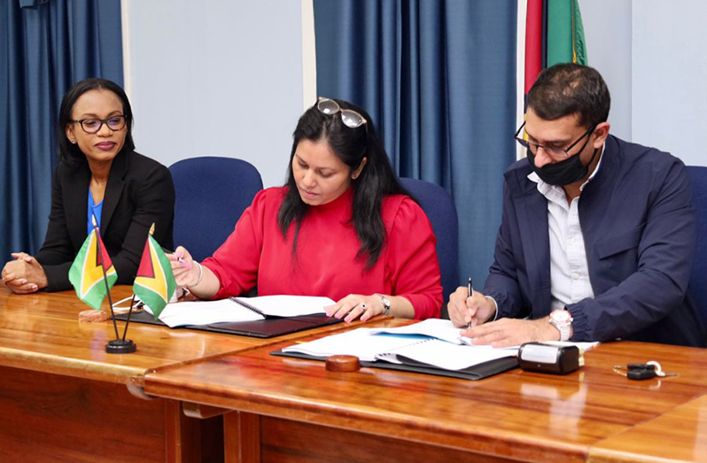 Permanent Secretary of the Tourism, Industry and Commerce Ministry, Sharon Roopchand-Edwards and Chairman/Managing Director of NABI Construction Inc, Shir Affron Nabi sign the agreement for the construction of the new GNBS facility as subject Minister, Oneidge Walrond looks on (Ministry of Tourism, Industry and Commerce photo)