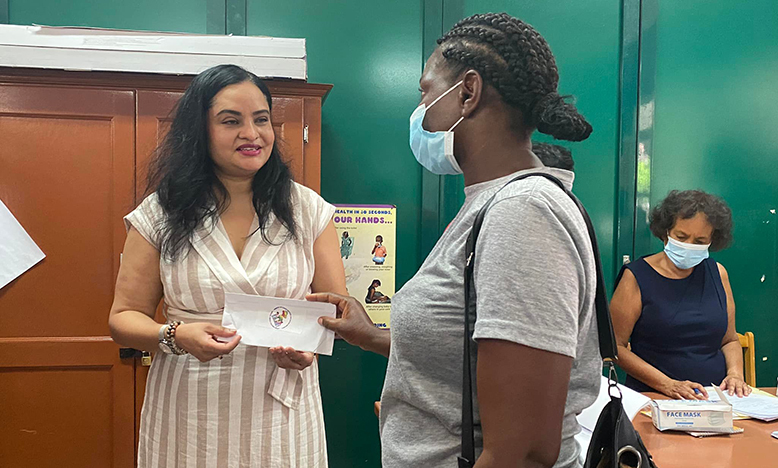 Human Services and Social Security Ministry, Dr. Vindhya Persaud hands over the first Special Needs Cash grant to single mother, Dellorn Adams
