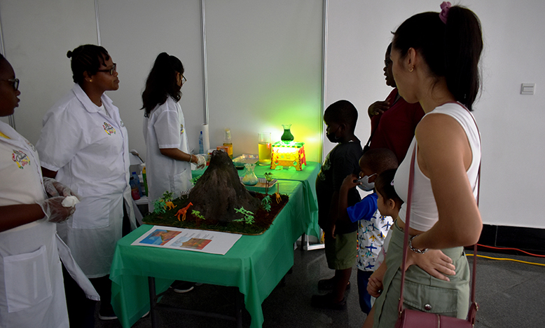 Attendees at the fair visiting an interactive experiment booth showcasing a volcano (Guyana Chronicle photo)