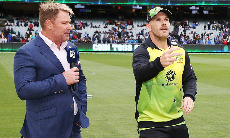 Aaron Finch (right) and Shane Warne at the coin toss before a T20 match against India at the MCG in 2018 (Getty)