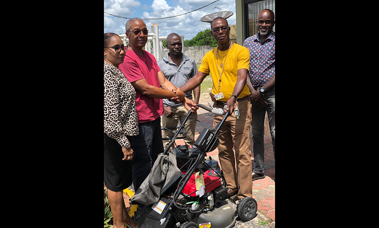 From left, Dr Joseph Haynes and Mrs Haynes hand over the lawn mower to MSC president Avery Trim in the presence of MSC executives, Joseph Chapman and Norris King