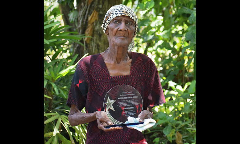 Mildred Agatha Halley displaying her plaque which was presented by the church