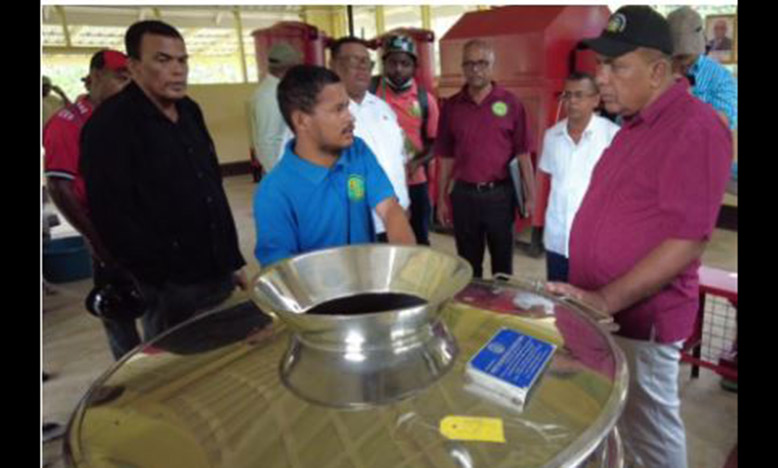 NAREI’s representative explaining the process of grinding ginger to Minister Mustapha and others