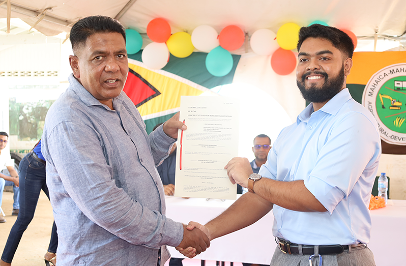 Agriculture Minister Zulfikar Mustapha presents Vevekeanand Ramnarace, 21, with his lease at the Open Day