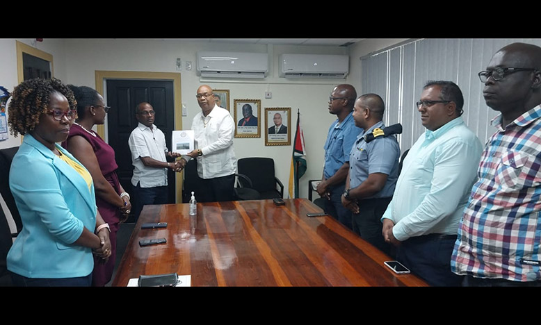 Captain Joseph Lewis (left) hands over the report to Public Works Minister, Juan Edghill