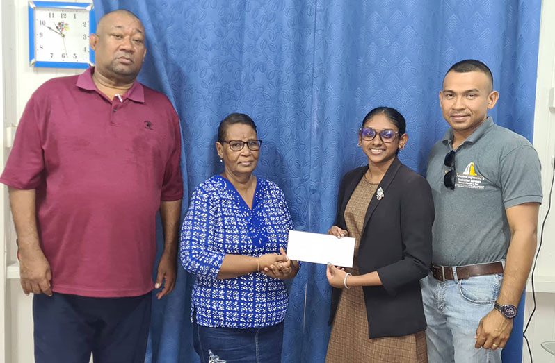 Legal Clerk Devya Roopnarine hands over sponsorship to BCB secretary Angela Haniff in the presence of Hilbert Foster and Nolan France
