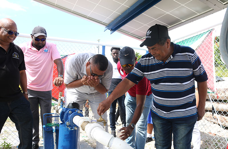 Minister of Housing and Water, Collin Croal drinks from the water supply system that was commissioned in Isseneru, Region Seven, where residents received first-time access to potable water