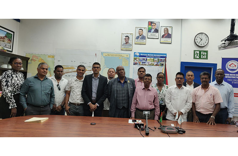GWI’s Chief Executive Officer Shaik Baksh (fourth from right) flanked by contractors and GWI officials after  signing of the contracts (GWI photo)