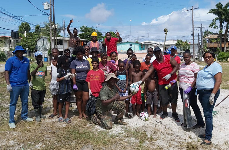 Director of Sport, Steve Ninvalle (left), with youths and other residents of the West Ruimveldt area during yesterday’s clean-up exercise