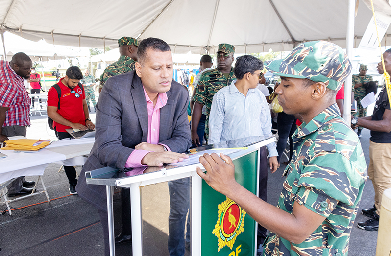 Minister of Housing and Water, Collin Croal in discussion with one of the many soldiers interested in building their homes