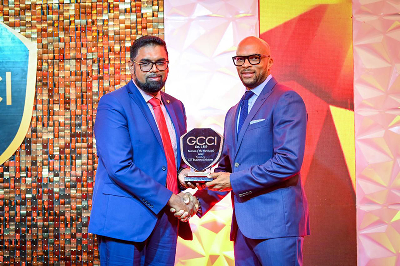 President, Dr. Irfan Ali presents the award to Chief Operations Officer (COO) of Business Solutions, Orson Ferguson