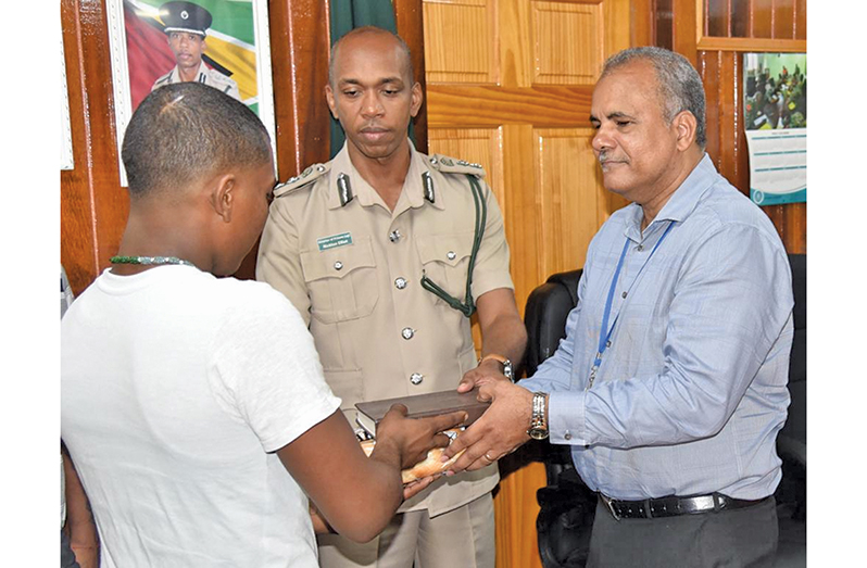 Chief Executive Officer of Food for the Poor, Kent Vincent and Director of Prisons, Nicklon Elliot, interact with the two prisoners (Guyana Prison Service photos)