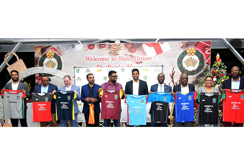 President Irfaan Ali (centre) posing with Region Four's team jersey and flanked by Minister of Culture, Youth & Sport, Charles Ramson Jr (right) and E-Networks' Principal, Vishok Persaud (left) (Elvin Croker  photo)