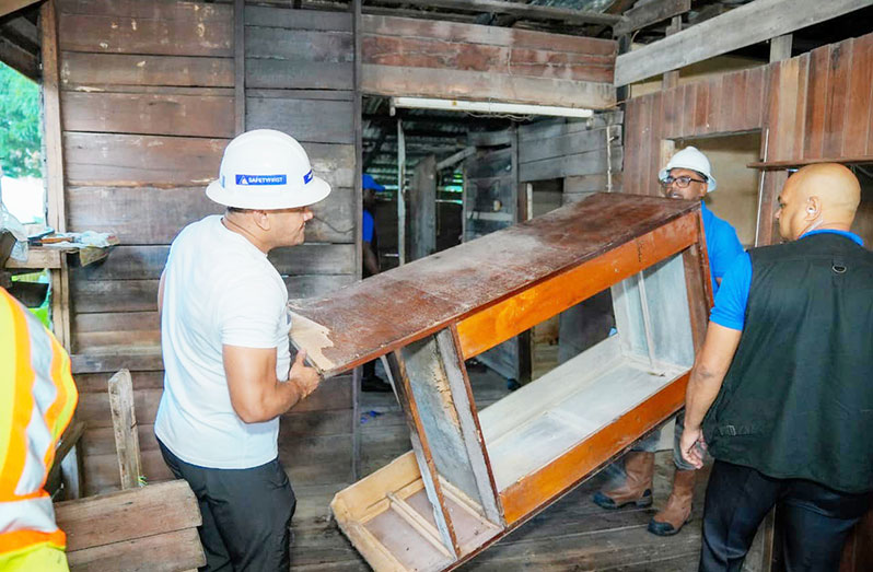 Leading from the front! President Dr. Irfaan Ali and other officials dismantled the dilapidated structure that 85-year-old Meena Bafan occupied (Office of the President photo)