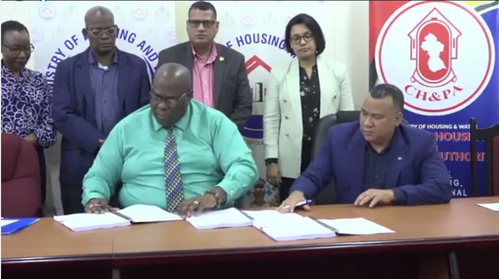 Minister of Housing and Water Collin Croal and Minister within the Ministry Susan Rodrigues witness the signing of the multimillion dollar contract for improved efficiency of the agency